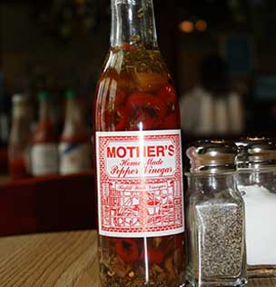 a bottle of pepper vinegar, pepper and salt